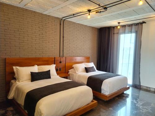 乔卢拉Hotel Tila的一间卧室设有两张床和窗户。