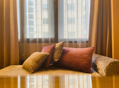台北Artinn藝築文旅-台北站前館的一组枕头坐在窗前的床上