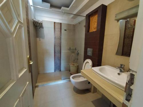 那格浦尔Hotel Sukhakarta, Nagpur的浴室配有卫生间、盥洗盆和淋浴。