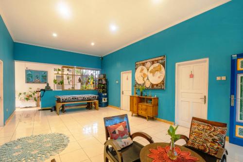 日惹日惹乐佛旅舍的客厅拥有蓝色的墙壁和桌椅