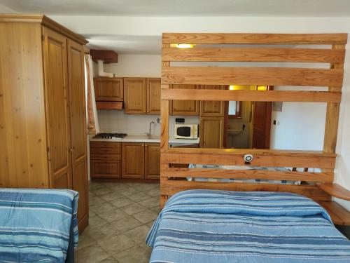 塞斯特雷勒泰特公寓的一个带木制橱柜的厨房和一张位于客房内的床