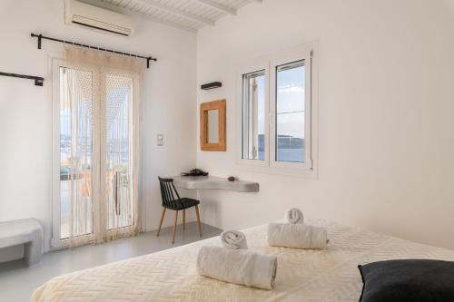 TagouYalos mykonos 3 bedroom Luxury home in Mykonos Town with Sea & Sunset view的白色卧室配有床和书桌