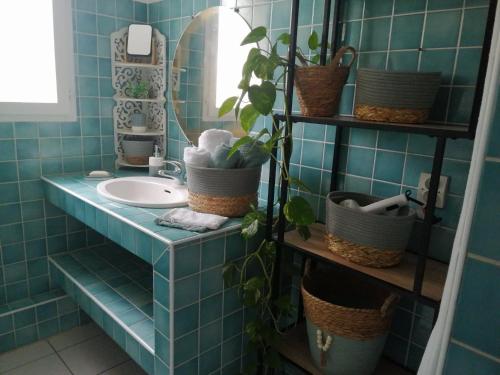 滨海萨纳里L'Ecrin d'Azur的蓝色瓷砖浴室设有水槽和镜子