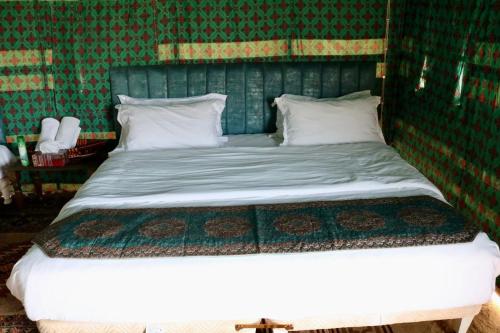 BadīyahRashid Desert Private Camp的绿色墙壁间的一张床位