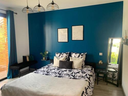 拉沙佩勒Appartement proche Astérix, Stade de France, Chantilly, Roissy, piscine saisonnière的一间卧室设有蓝色的墙壁和一张床