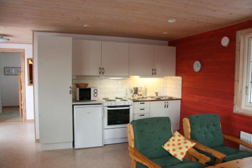 Bjällum霍尔波阿琼斯度假屋的一间厨房,内设白色橱柜和绿色椅子