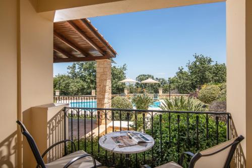 杰拉尼Gerani Villas的一个带桌椅的阳台和一个游泳池