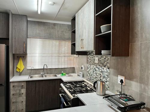 布隆方丹UStay Apartment - Westdene的小厨房配有炉灶和水槽