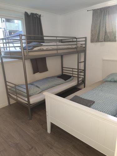 特罗姆瑟FeelHome 2 bedrooms apartment Vidarsveg的客房设有两张双层床和一张床。