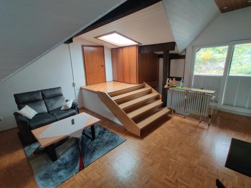 海姆巴赫Ferienapartment: An Der Kunstakademie Heimbach的一间带楼梯和沙发的客厅