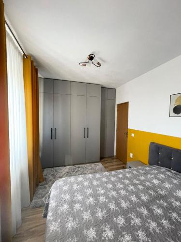 雅西Cozy Apartment - near Airport and Palas Mall的一间卧室配有一张床和吊扇