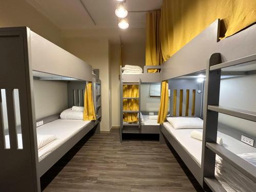 迪拜Business Backpackers JBR (BBJ)的客房设有3张双层床和黄色窗帘