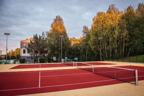 卡尔瓦里亚-泽布日多夫斯卡Pawilon Sportowo Turystyczny Kalwarianka的网球场,上面有两顶网球网