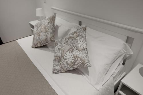 奇维塔韦基亚Central Guest House的一张带两个枕头的白色床