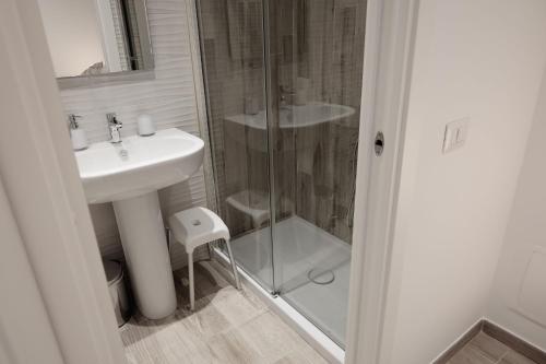 奇维塔韦基亚Central Guest House的一间带水槽和玻璃淋浴的浴室
