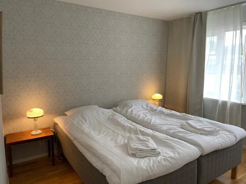 瓦斯泰纳Vadstena centrum的卧室内的一张床位,配有两盏灯和一扇窗户