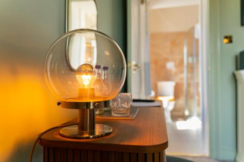 特科维尔特科维尔庄园酒店的木桌上的一盏灯,上面有玻璃圆顶