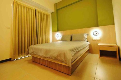 台南619Villa红树林的一间卧室设有一张床和绿色的墙壁