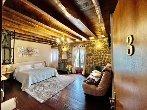 圣塞瓦斯蒂安Casa Rural Irigoien的一间卧室设有一张床和石墙