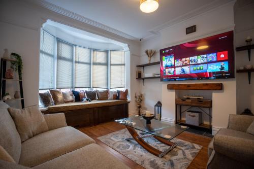 布莱克浦Cavendish Cat and Gaming House的带沙发和大屏幕电视的客厅