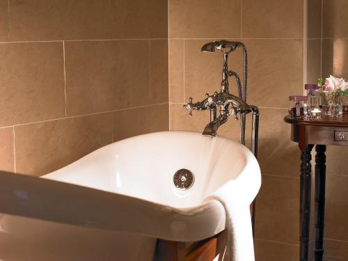赛马骑师赛马酒店的浴室设有浴缸和水龙头