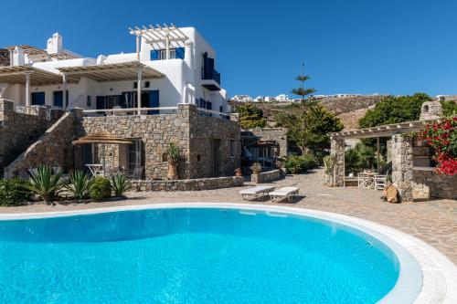 米克诺斯城Yalos Mykonos Ornos Pouli private apartments w shared swimming pool的一座带游泳池和房子的别墅