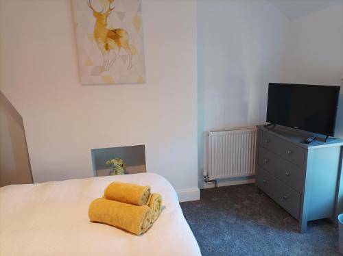 利物浦Victorian Renovation Room 8的一间卧室配有一张黄色毛巾的床