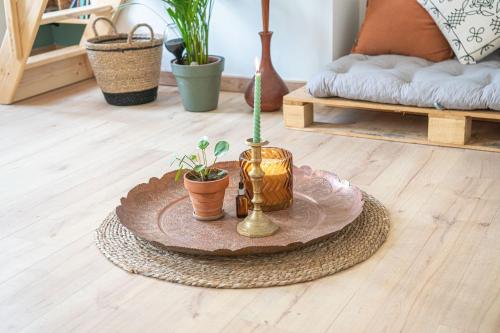 勒阿弗尔La maison bohème的一张桌子,上面有盆栽植物,铺在木地板上