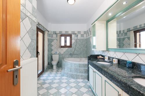 PeramaVilla Sevdas的一间带两个盥洗盆、浴缸和卫生间的浴室