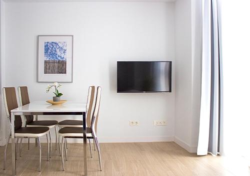 马拉加CENTRO PICACHO的用餐室配有桌椅和墙上的电视