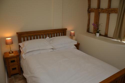 牛津Sabine Barn的卧室内的一张带白色床单和枕头的床