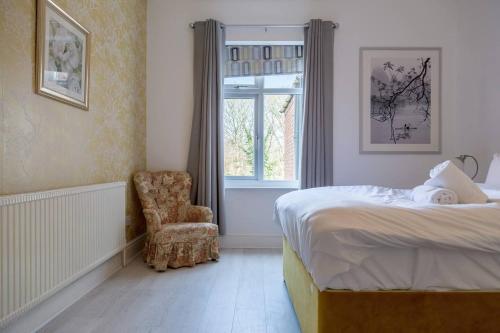 伯明翰Spacious 5 Bedroom House in Birmingham close to NEC For 12 Guests的卧室配有床、椅子和窗户。