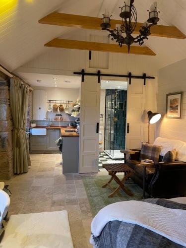 卢斯Charming stone Bothy at Loch Lomond的厨房以及带沙发和桌子的客厅。