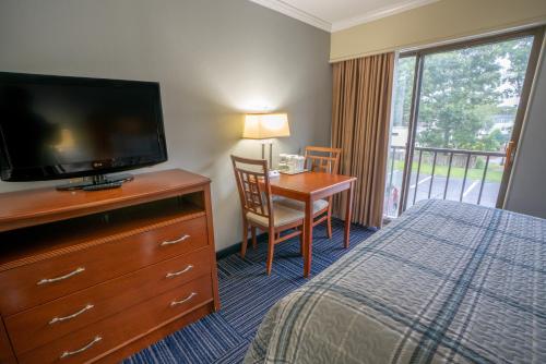 南雅茅斯All Seasons Resort, Trademark Collection by Wyndham的酒店客房配有一张床和一张书桌及一台电视