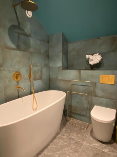 圣安德鲁斯Ailim House Serviced Cottage Escape, around the corner from the Old Course的浴室配有白色浴缸和卫生间。
