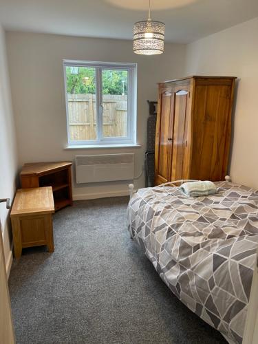 弗姆比Lovely 4 bed apartment in centre of Formby的一间卧室设有一张床和一个窗口