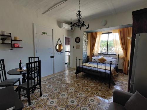 弗洛里亚纳Near Valletta City - Open Views - Ta Tessie Suite in Floriana - Malta的一间卧室配有一张床、一张桌子和一个窗户。