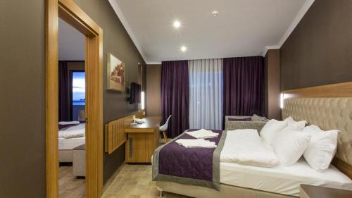 阿拉尼亚Michell Hotel & Spa - Adult Only - Ultra All Inclusive的配有一张床和一张书桌的酒店客房