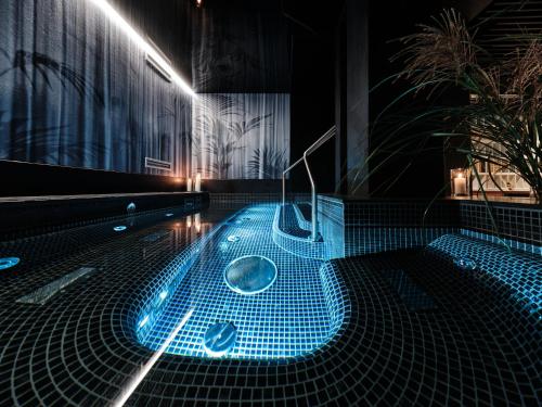 弗罗茨瓦夫Hotel Altus Palace的浴室设有蓝色灯光和浴缸。