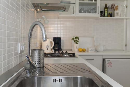 杜布罗夫尼克杜布罗夫尼克孙卡纳公寓的白色的厨房设有水槽和炉灶。