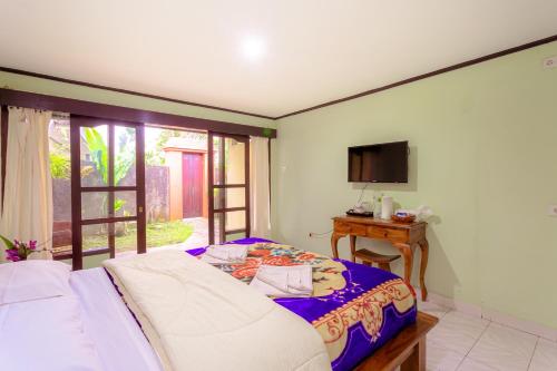 贝都古Pacung Indah Hotel & Restaurant by ecommerceloka的一间卧室配有一张床、一张桌子和一台电视