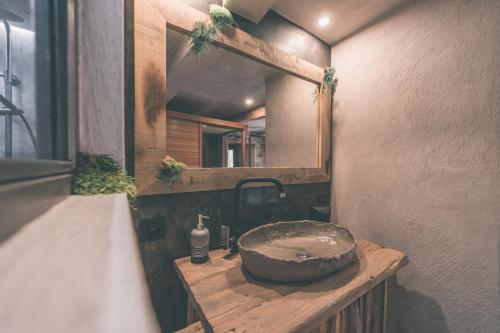 斯图蒙Romantic Getaway - Sauna and Jacuzzi - El Clandestino的一间带石制水槽和镜子的浴室