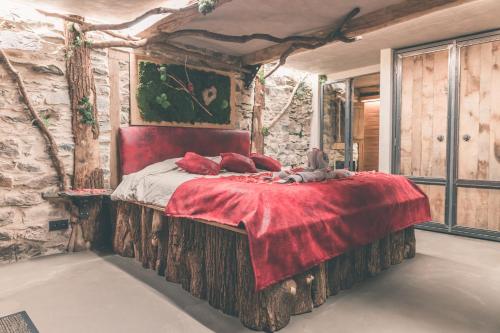 斯图蒙Romantic Getaway - Sauna and Jacuzzi - El Clandestino的卧室配有一张石墙内的大床