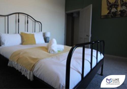 New BrancepethLuke Stays - Alum Waters的一间卧室配有带白色床单和黄色枕头的床。