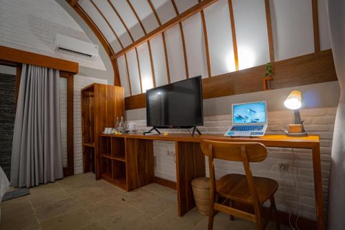塞隆贝拉纳克Driftwood Lombok的客房设有带笔记本电脑和显示器的书桌。