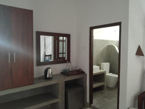 马特勒Beach Inns Holiday Resort - Celeste的一间带水槽、镜子和卫生间的浴室