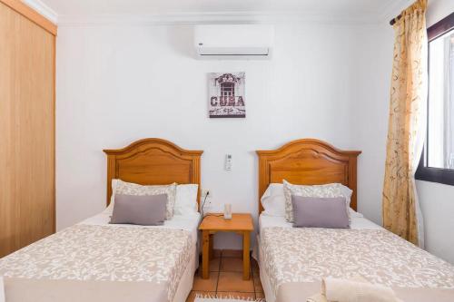 蒂亚斯Casa Bellavista的一间卧室配有两张床和一张小桌子