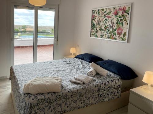 穆特克萨梅尔Résidence Bahia Golf的一间卧室配有一张带蓝色枕头的床和一扇窗户。