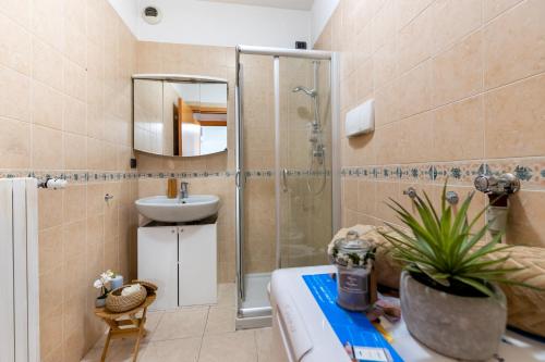米兰Appartamento Bicocca - Affitti Brevi Italia的带淋浴、盥洗盆和镜子的浴室