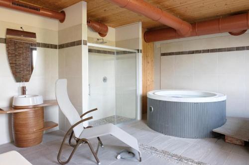 瓜热讷乐博迪酒店的带浴缸和椅子的浴室